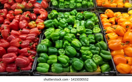 Piles of bell peppers organized at the counter of a supermarket or grocery store. Green, red, orange and yellow bell peppers for sale. - Powered by Shutterstock