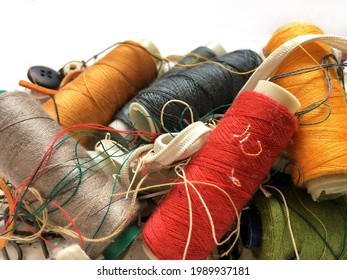 Piles of colorful threads mixed with sewing equipment, looks messy