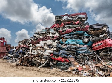 piles of crushed cars at a scrapyard - Powered by Shutterstock