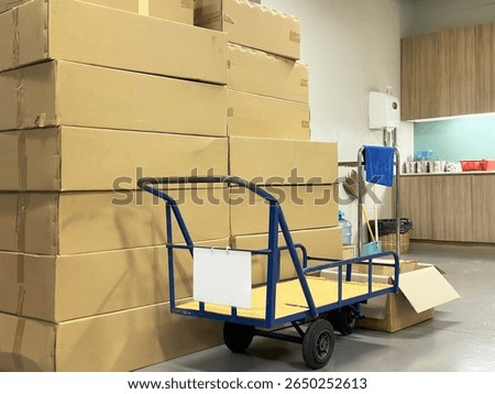 Piles of empty boxes and a trolley at the storage room