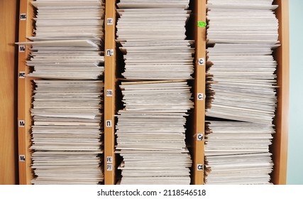 
Piles of files Multiple rows of filing cabinets in an office or medical establishment, overflowing with files.