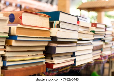 Piles of old books on a table in blur background