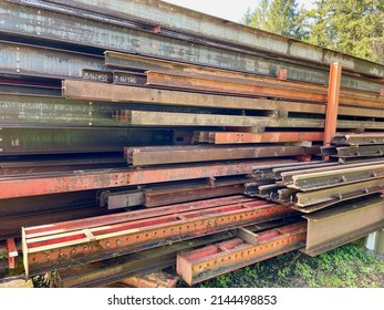 Piles Of Red Steel Beams In Outdoor Storage. High Quality Photo