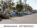 Piles of rubbish on street side from severely damaged houses after hurricane in Florida mobile home residential area. Consequences of natural disaster