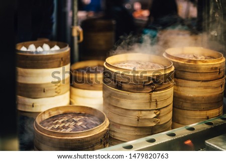 Piles of stacking bamboo steamers are steaming for dim sum. Street food of Jiantan in Taipei, Taiwan. Focus on front bamboo steamers.