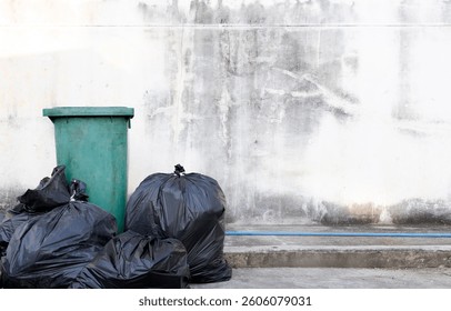 Piles of trash and overflowing bins against a dirty wall with recycling icons. Concept of waste management, pollution, and environmental awareness.