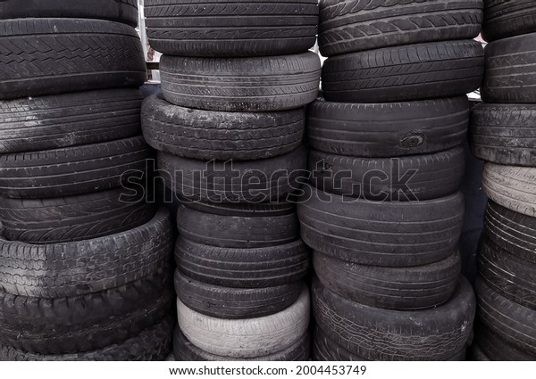piles of used car tires that are no longer\
used on display in a car repair\
shop