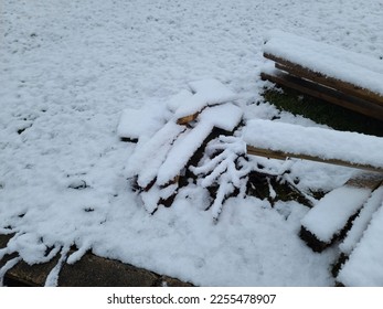 Piles of wood and stakes lying on the ground and covered in snow. - Shutterstock ID 2255478907