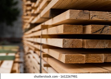 Piles of wooden boards in the sawmill, planking. Warehouse for sawing boards on a sawmill outdoors. Wood timber stack of wooden blanks construction material. Industry.