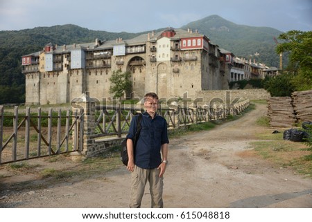 Pilgrim on the background of the monastery in Athos