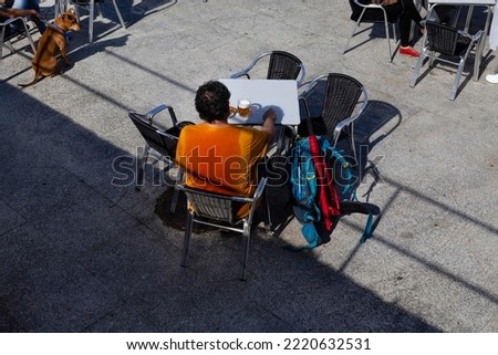 A pilgrim rests on the terrace of a bar in the Plaza de Santa Liberata in Baiona