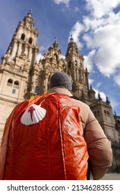 pilgrim woman in Obradoiro square looking the Santiago de Compostela cathedral after finishing the way of st James , Galicia, Spain ; focus in foreground