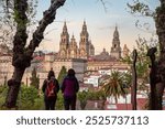 Pilgrims enjoying the sunset over Santiago de Compostela, seen from the famous cathedral viewpoint in the Alameda park, Galicia in Spain