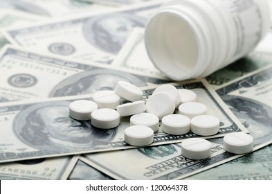 Pill Bottle On A Pile Of Hundred Dollar Bills Suggesting The High Cost Of Health Care