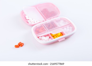 Pill Box With Colorful Pills And Vitamins. Plastic Pink Container With Cells For Medicines. Health Concept. Selective Focus, Close-up.