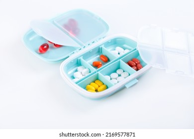 Pill Box With Colorful Pills And Vitamins. Plastic Blue Container With Cells For Medicines. Health Concept. Selective Focus, Close-up.