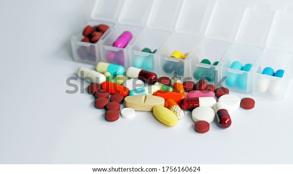 Pill box daily take a medicine, with colorful of\
pills, tablets, and capsules. Drugs use for treatment and cure the\
disease. Medication in medical clinic isolated in white background,\
has copy space.