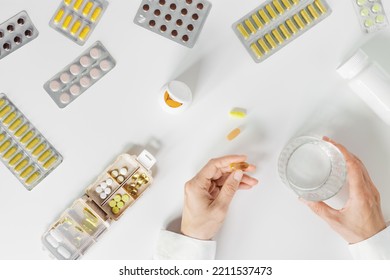Pill Box Daily Taking Medicine, With Tablets And Capsules. Medication As Alternative Medicine For Treatment And Good Health. Medicine Dose Box With Pills And Glass Of Water In Women Hands On Table
