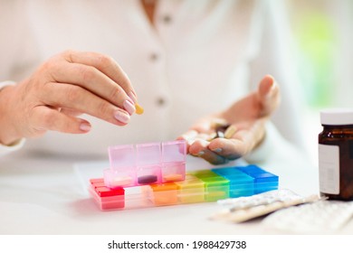 Pill box for senior patient. Medicine container. Elderly woman sorting drug pills for pain relief and disease treatment. Sick retired female with drugs. Daily vitamins for healthy retirement. - Powered by Shutterstock