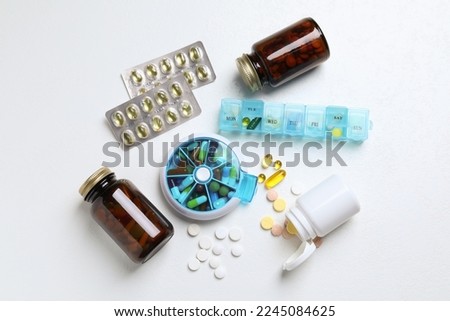 Pill boxes with medicaments on white table, flat lay