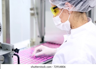 Pill Manufacturing.Pharmaceutical Industry.Medicine Production.Women in Protective Clothing Working at the Pharmaceutical Factory.Technician Inspecting the Quality of Pills at a Pharmaceutical Plant. 