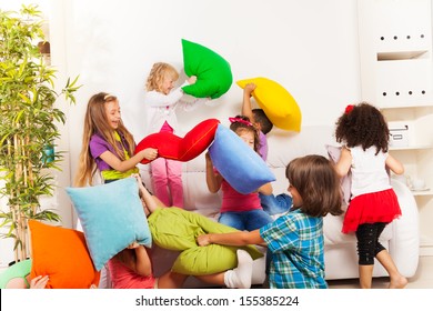 Pillow Fight - Large Group Of Kids Actively Playing With Pillow In The Living Room On The Coach