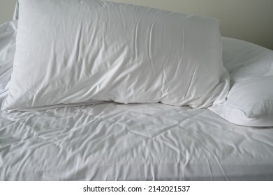 Pillow Wearing White Pillowcases And White Satin Sheets,duvet Crumpled After People Got Out Of Bed. Soft Bedding Set Are Suitable For Sleeping And Relaxing.