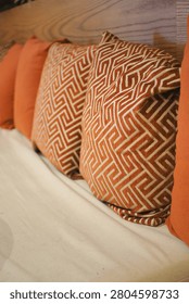 Pillows with a geometric pattern sit on a white sofa in a room.