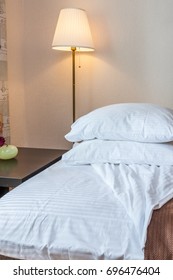pillows on bed and lamp with table in bedroom 