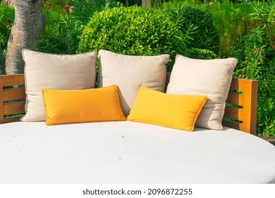 Pillows On Outdoor Patio Chair With Umbrella In Garden