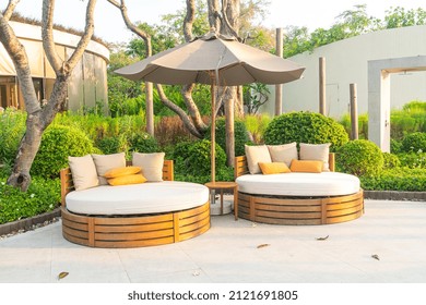 Pillows On Outdoor Patio Chair With Umbrella In Garden