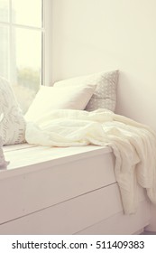 pillows and warm knitted plaid on a windowsill, a cozy corner, a cozy window sill.