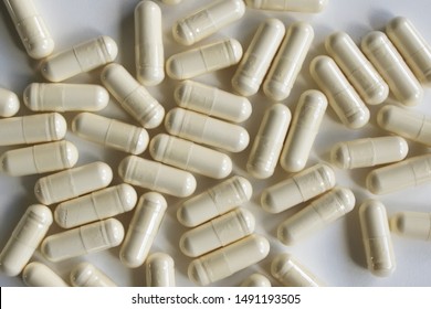 Pills capsules with colostrum, on a white background