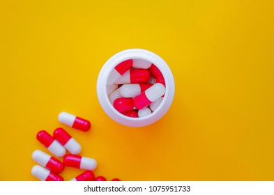 Pills capsules pill bottle isolated on yellow. Top view with copy space. Medicine pharmacy pharmacology health concept