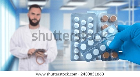 Pills in doctor hands. Blisters with antibiotics for treatment. Pharmacological drugs. Doctor in blurred white coat. Experienced medic holds pills for treatment. Painkillers inside clinic