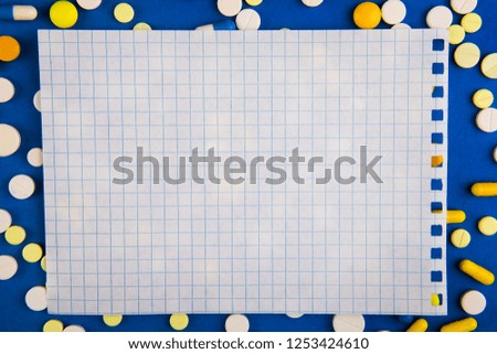 Pills and Empty Paper on the Blue Paper Background