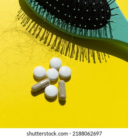 Pills and fallen hair on a yellow background. Baldness and hair loss problem - Shutterstock ID 2188062697