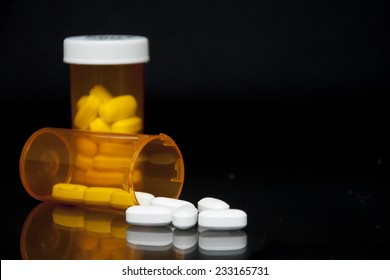 Pills Falling Out Of Prescription Bottle On Black