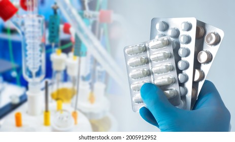 Pills Hand Doctor. Pills On Background Of Medical Equipment. Pills In A Package In Man Hand. Concept For Production And Sale Of Tablets. Manufacturing Of Medicines. Medicines Near Blurred Bioreactor.