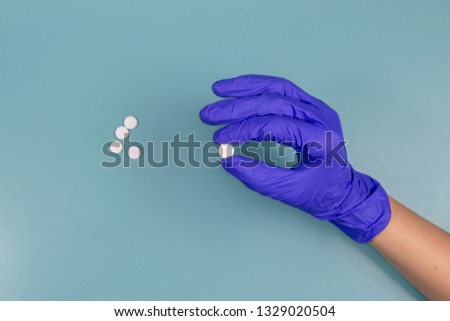 pills in hand on blue background. 