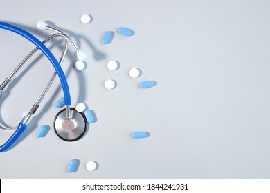 Pills or pills lying next to stethoscope on gray background with conceptual copy space medicine, healthcare and medication treatment - Shutterstock ID 1844241931