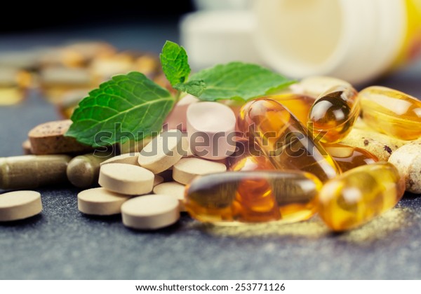 pills and multivitamins on a dark background, closeup