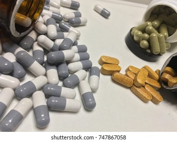 Pills And Opioid Addictions Open Pill Bottle On White Counter Big Pharma Makes Lots Of Money Off Of The Pharmaceutical Industry Capsules , Vitamins , And Pills