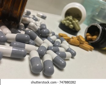 Pills And Opioid Addictions Open Pill Bottle On White Counter Big Pharma Makes Lots Of Money Off Of The Pharmaceutical Industry