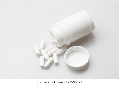 Pills And Pill Bottle On White Background.