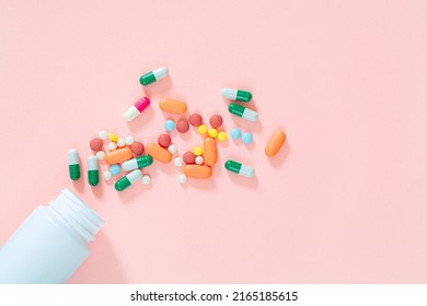 pills and pill bottles on pink background,Assorted pharmaceutical medicine pills, tablets and capsules and bottle on pink background. Top view. Flat lay. Copy space. Medicine concept. Heap of pills on
