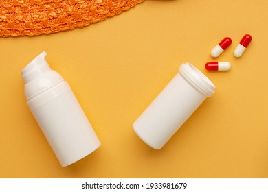 Pills And Protective Cosmetics On Orange Background. Allergy To The Sun In The Summertime. Tourism And Vacation On Coronavirus Infection Time.