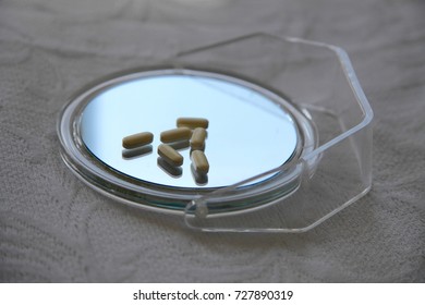 Pills Reflected On A Hand Held Mirror