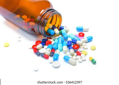 Pills Spilling Out Of Pill Bottle On White Background