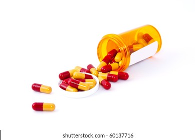 Pills Spilling Out Of Pill Bottle Isolated On White.